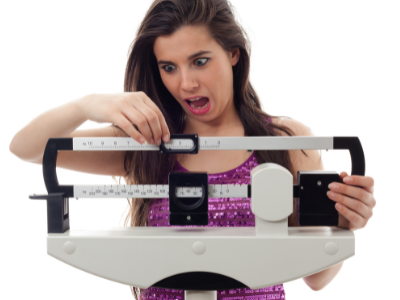 Woman on scale surprised she gained weight from fad diets