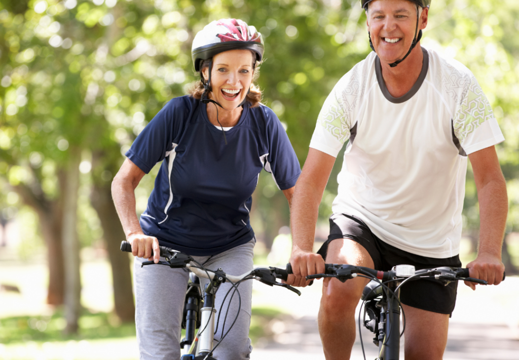 Middle aged man and woman enjoying biking with happy smiles